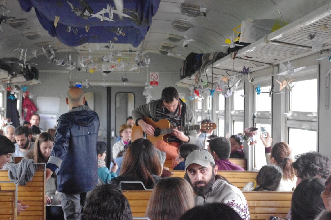 Ashod Papasian playing the guitar on the inaugural train ride. Photo credit: Setrag Shahikian
