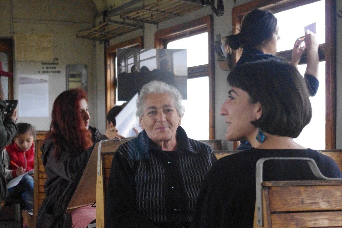 Curator Anna Gargarian talks with a passenger about “In Motion.” Photo credit: Setrag Shahikian